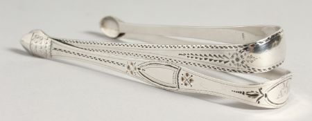 TWO GEORGE III BRIGHT CUT SUGAR TONGS. London 1791, maker W C & 1794, maker Peter and Ann Bateman.