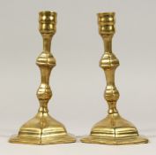 A PAIR OF GEORGIAN BRASS CANDLESTICKS, 7ins high.