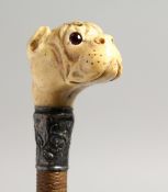 A 19TH CENTURY WHIP, the handle as a carved ivory bulldog and bear with glass eyes and silver band.
