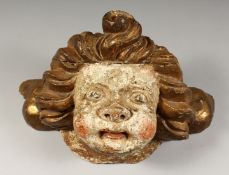 A 17TH CENTURY CARVED LIMEWOOD CHERUBS HEAD. 17ins long x 8ins high.