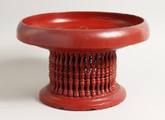 AN EASTERN WOODEN RED LAQUER CIRCULAR PAINTED TEMPLE STAND. 11.5ins diameter.