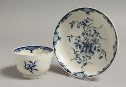 AN 18TH CENTURY WORCESTER TEABOWL AND SAUCER, painted inthe blue with a large trailing flower,