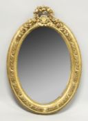 A SMALL GILT OVAL MIRROR 3ft high.