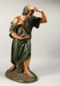 A LARGE CARVED WOOD RELIGIOUS FIGURE carrying a cap. 24ins high.