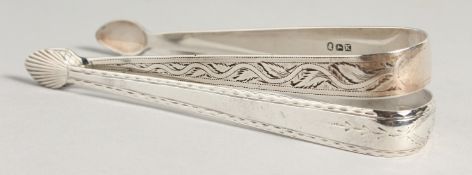 TWO GEORGE III BRIGHT CUT SUGAR TONGS. Maker N S & CO. and London 1805, maker A B +.