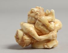 A CARVED BONE EROTIC NETSUKE.