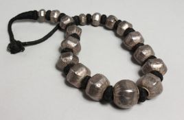 AN ISLAMIC SILVER AND BLACK BEAD NECKLACE.