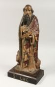 A 17TH CENTURY CARVED WOOD FIGURE OF ST LUC, a bull at his feet. Inscribed on base.