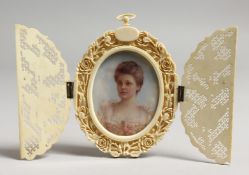 AN EDWARDIAN OVAL PORTRAIT MINIATURE OF A YOUNG LADY, bust length, housed in a pierced ivory