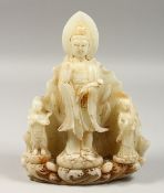 A CHINESE CARVED WHITE JADE GUANYLIN GROUP, 11ins high