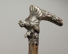 A GOOD 19TH CENTURY RUSTIC WALKING STICK, the silver handle with a pheasant and a branch. 34ins