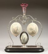 A SUPERB AUSTRALIAN CENTREPIECE, a plated stand with three carved emu egg; aborigine, emu and