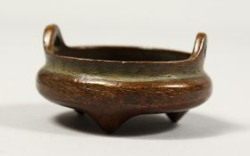 A SMALL CHINESE BRONZE CIRCULAR CENSER with handles, impressed mark, 2ins diameter.