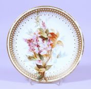 A WORCESTER FLORAL PLATE with gilt border. 8.5ins diameter.
