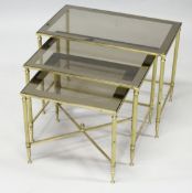 A NEST OF THREE BRASS AND SMOKED GLASS OCCASIONAL TABLES. Largest 2ft wide x 1ft 2ins deep x 1ft