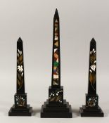 THREE BLACK MARBLE INLAID OBELISKS with lily of the valley and other flowers. 13ins x 10ins (3).