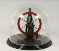 A MODEL STEAM ENGINE in a circular glass dome.
