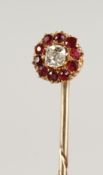A DIAMOND AND RUBY CLUSTER TIE PIN, cased.