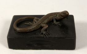 A BRONZE LIZARD on a marble base. 5ins long.