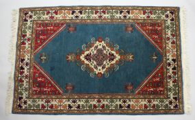 A PERSIAN DESIGN RUG, blue ground with a central diamond shape floral design. 6ft 2ins x 4ft.