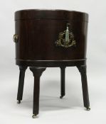 A VERY GOOD GEORGE III MAHOGANY OVAL WINE COOLER with crossbanded rising top opening to reveal a