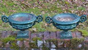 A SMALL PAIR OF TWO-HANDLED GREEN PAINTED CAST IRON CIRCULAR URNS. 12ins diameter.