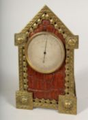 A SMALL GILT METAL AND LEATHER GOTHIC DESIGN CLOCK. F L WEST, LONDON 6.5ins high.