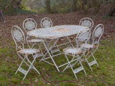 A WHITE PAINTED PIERCED METAL FOLDING GARDEN TABLE AND SIX CHAIRS