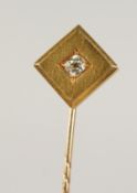 A GOLD AND DIAMOND SET TIE PIN, cased.