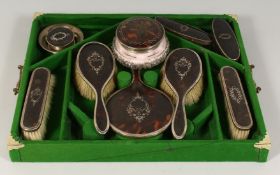 A GOOD SILVER MOUNTED TORTOISESHELL DRESSING TABLE SET comprising; hand mirror, brushes and bottle.