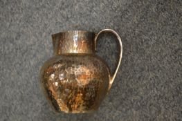 A hammered silver cream jug.