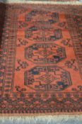A Persian rug, red ground with four central large motifs.