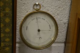 A circular brass barometer.