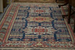 A Persian design carpet, dark blue and turquoise ground with three large central motifs.