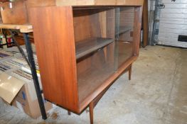 A mid-century hardwood bookcase with sliding doors.