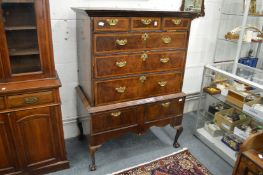 An 18th century walnut and feather banded chest on stand with three frieze drawers, three long