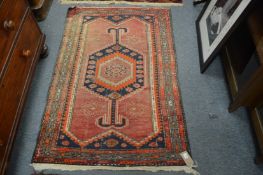 A small pink ground Persian rug.