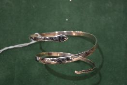 A white metal snake bangle.