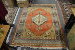 A Persian design carpet, orange ground with stylized decoration.