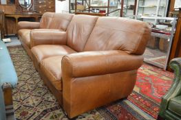 A modern brown leather upholstered two seater settee.