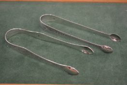 TWO GEORGE III BRIGHT CUT SUGAR TONGS. London 1802, maker Peter, Ann and William Bateman & London