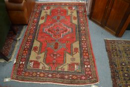 A Persian rug, red ground with stylized decoration.