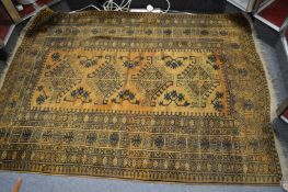 A gold ground Afghan rug.