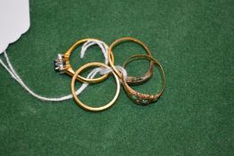 A group of four gold rings.