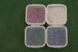 Four small boxes of coloured spinels.