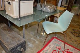 A frosted glass and chrome framed dining table with five designer chairs.