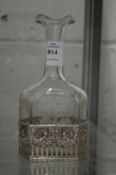 A silver mounted engraved glass bottle.