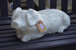 A composite garden ornament modelled as a reclining pig.