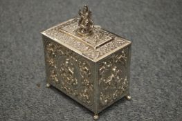 An Indian white metal tea caddy with hinged cover and embossed decoration.