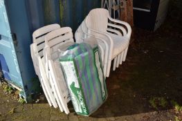 A pair of plastic lounging chairs and four stacking armchairs.
